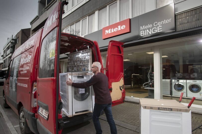 Peter, de eigenaar en technieker van Miele Center Bingé plaatst toestellen in zijn Miele-bestelwagen om later bij klanten nieuwe Miele toestellen te leveren, plaatsen en installeren